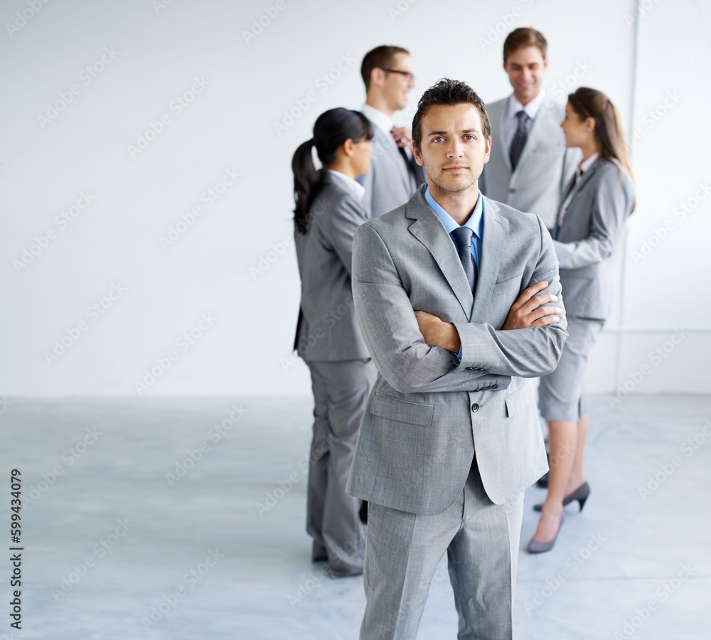 On the outskirts. Portrait of a handsome young businessman with his colleagues standing in the background. On the outskirts. Portrait of a handsome young businessman with his colleagues standing in the background.