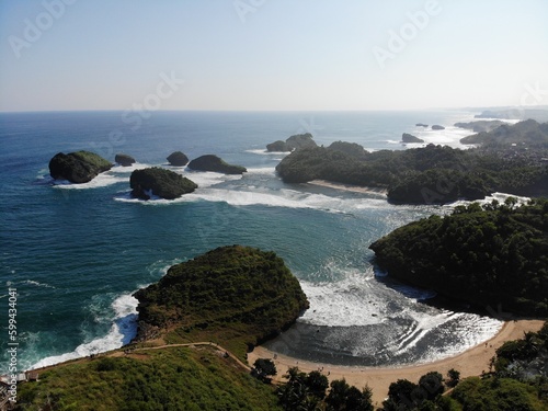 The beautiful landscape and scenery of ocean during sunset and sunny day. The long coastal beach with sand and rocky beach. Location in Pacitan, East Java Province, Indonesia.