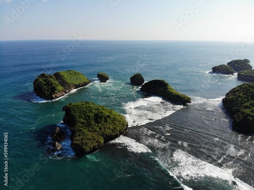 The beautiful landscape and scenery of ocean during sunset and sunny day. The long coastal beach with sand and rocky beach. Location in Pacitan, East Java Province, Indonesia.