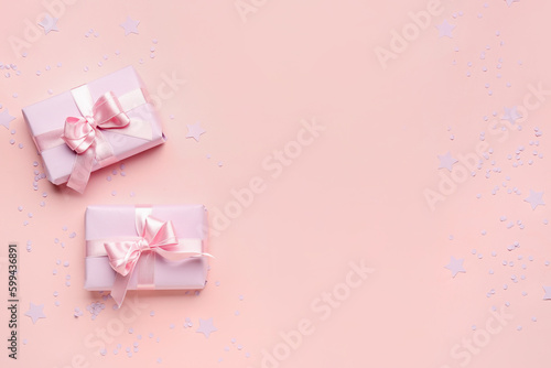 Gift boxes with beautiful bows and confetti on pink background © Pixel-Shot