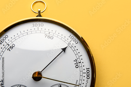 Aneroid barometer on yellow background