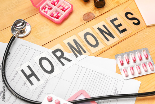 Word HORMONES with pills an...