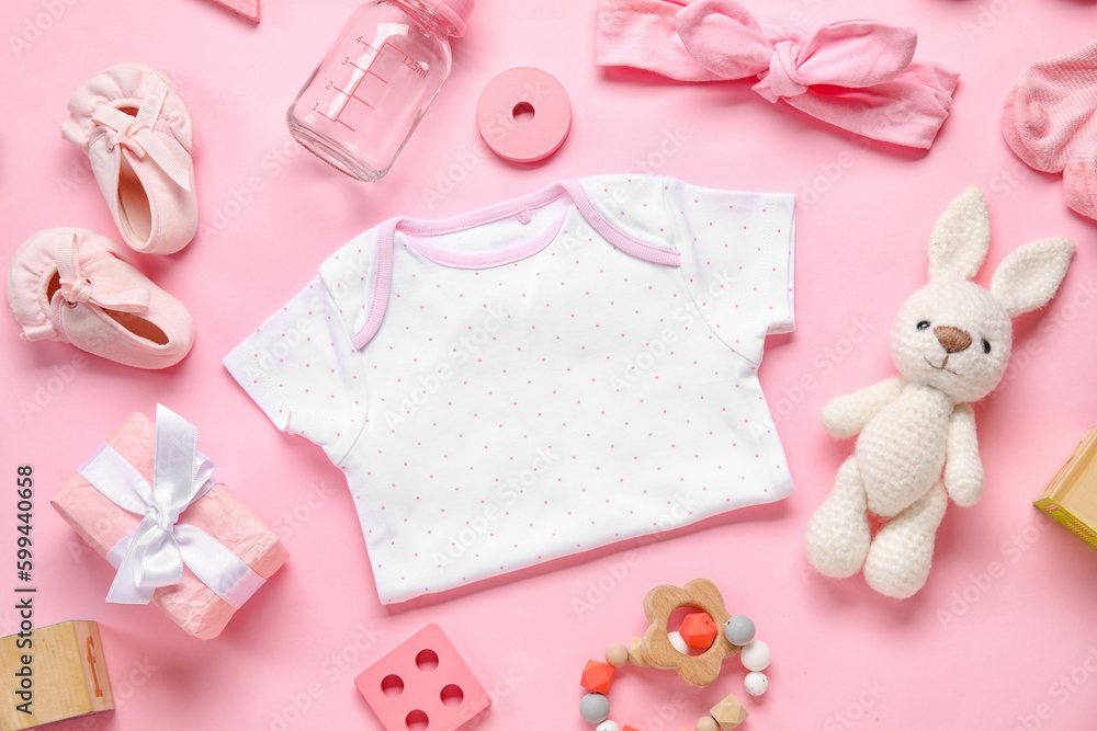 Composition with baby clothes, toys and accessories on light pink background Composition with baby clothes, toys and accessories on light pink background