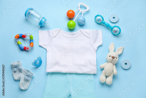 Composition with baby clothes, toys and accessories on blue background