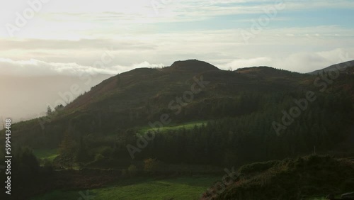 Green hill with trees, blue sky, and clouds. Ireland photo