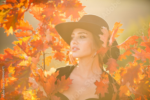 Portrait of young woman with autumn leafs. Romantic girl dream, hold fall maple leaves. Autumnal season.