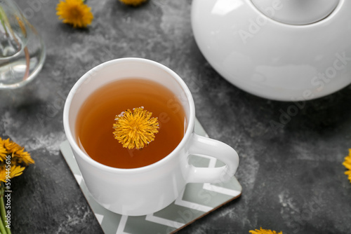 Cup of healthy dandelion tea on grey background