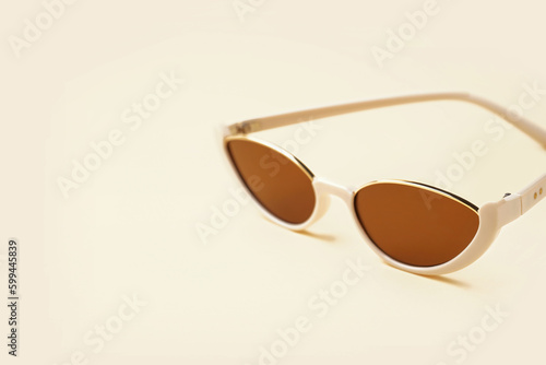 Stylish sunglasses on beige background