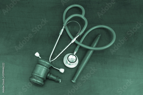 Broken wooden gavel and stethoscope on table, top view. Malpractice and medicine out of law concept.
