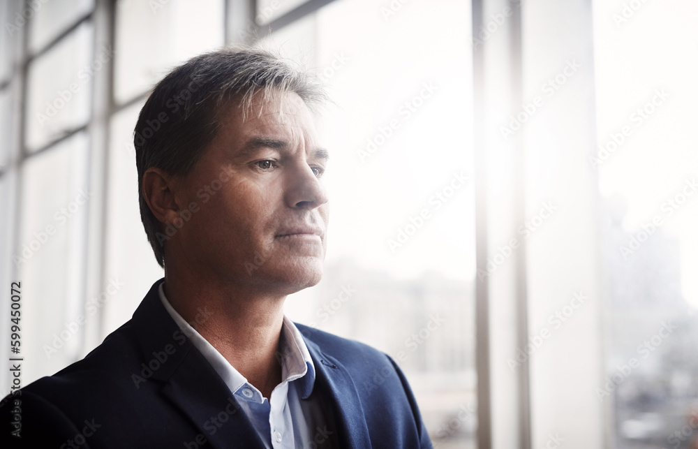 Dreaming gives us the motivation to keep achieving. a mature businessman looking out a window in an office. Dreaming gives us the motivation to keep achieving. a mature businessman looking out a window in an office.