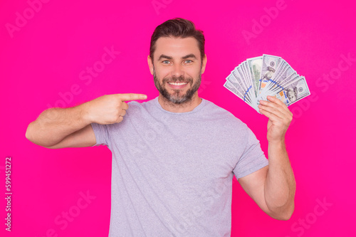 Man with money cash. Dollar banknotes. Portrait of man holding bunch of money banknotes. Dollar bills, credit, online banking. Rich man pointing at dollar banknotes, bank loan, financial savings.