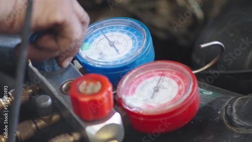 Close up Technician auto mechanic hand checking car air conditioner system car at garage. Refill automobile ac compressor