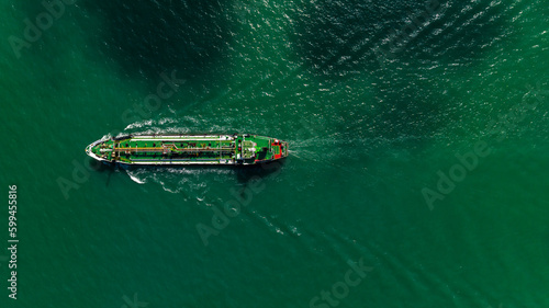 Aerial top view Oil ship tanker sailing full speed with beautiful wave and splash water in line of transportation from refinery in sea. © SHUTTER DIN