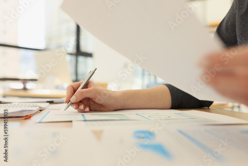 Accountant examines reports with diagrams and statistics © megaflopp