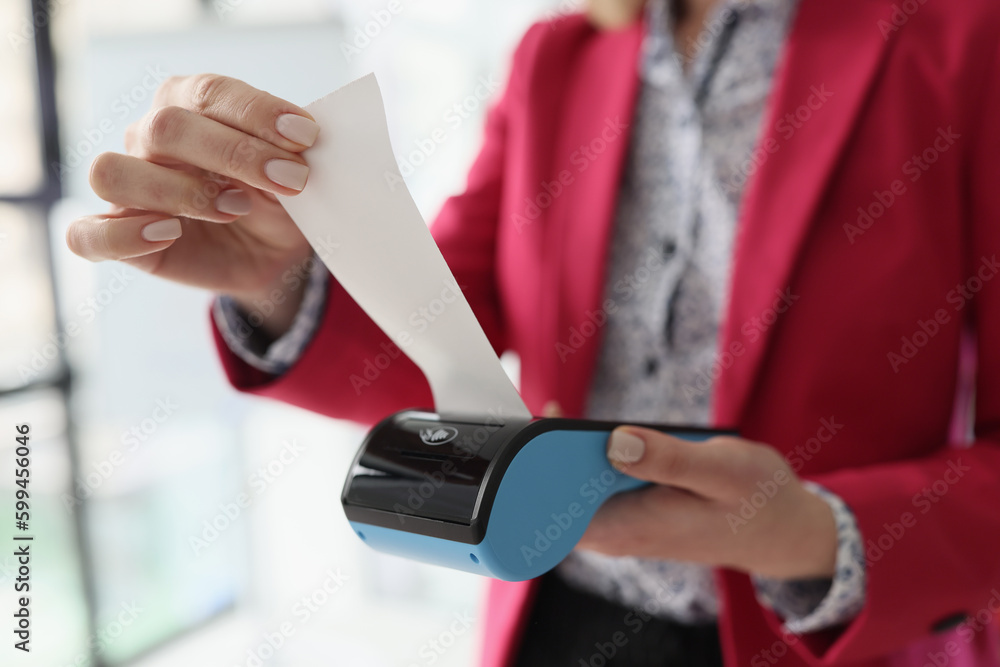Secretary holds terminal in hand tearing off paper check