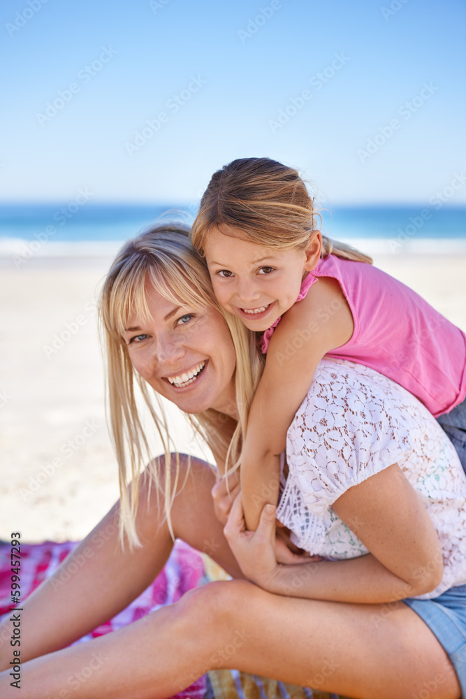 Fun times with mommy. Portrait of a loving mother and her daughter sitting together on the beach.
