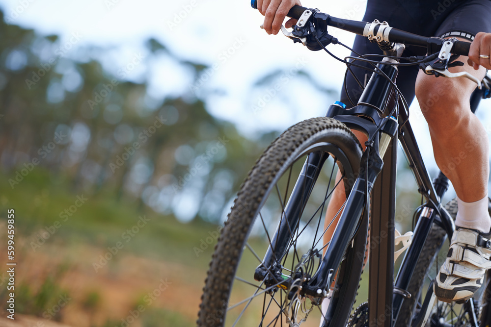 Mountain biking is addictive. Cropped view of a cyclist exploring outdoor terrain on his bike. Mountain biking is addictive. Cropped view of a cyclist exploring outdoor terrain on his bike.