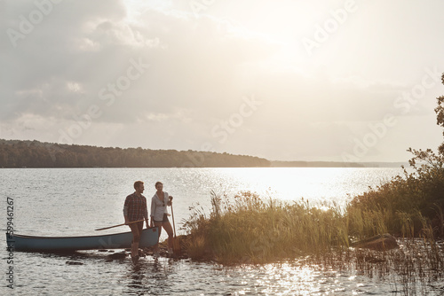 Their dream dates involve being outdoors. a young couple going for a canoe ride on the lake.