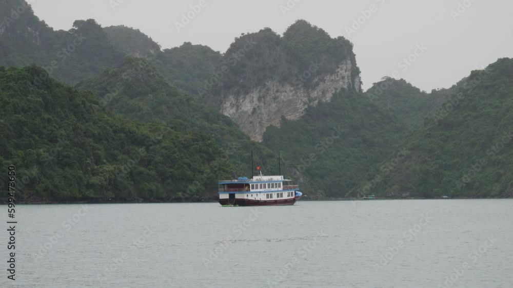 Old Cruise Ship Passing On Karst Mountains In Ha Long Bay, Northeast Vietnam. Wide shot Old Cruise Ship Passing On Karst Mountains In Ha Long Bay, Northeast Vietnam. Wide shot