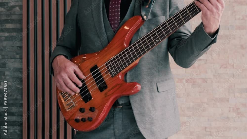 Bass guitar player playing the bass at a gig. Live performance with a rock instrument.