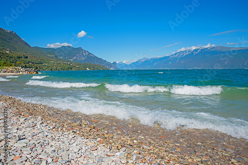 gravel beach Toscolano, lake shore Gardasee, tourist summer destination italy