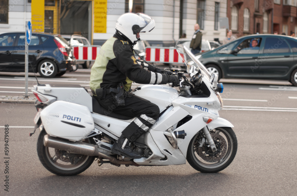 Police, motorbike and road safety officer working for protection and peace in an urban neighborhood in Denmark. Security, law and legal professional or policeman on a motorcycle ready for service