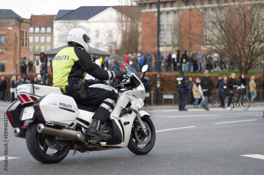 Emergency, motorbike and police or safety officer working for protection and peace in an urban town in Denmark. Security, law and legal professional or policeman on a motorcycle ready for service