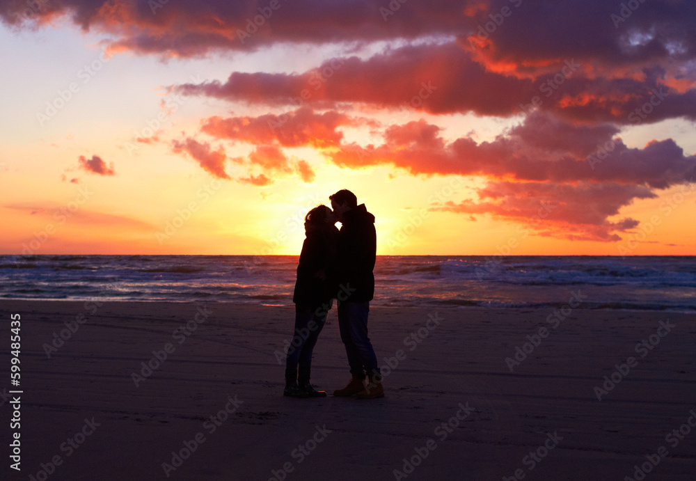 Kiss, silhouette people together at sunset and on seaside together for honeymoon. Care or love, holiday and shadows of couple on the beach or sea for romantic date outdoor on summer vacation