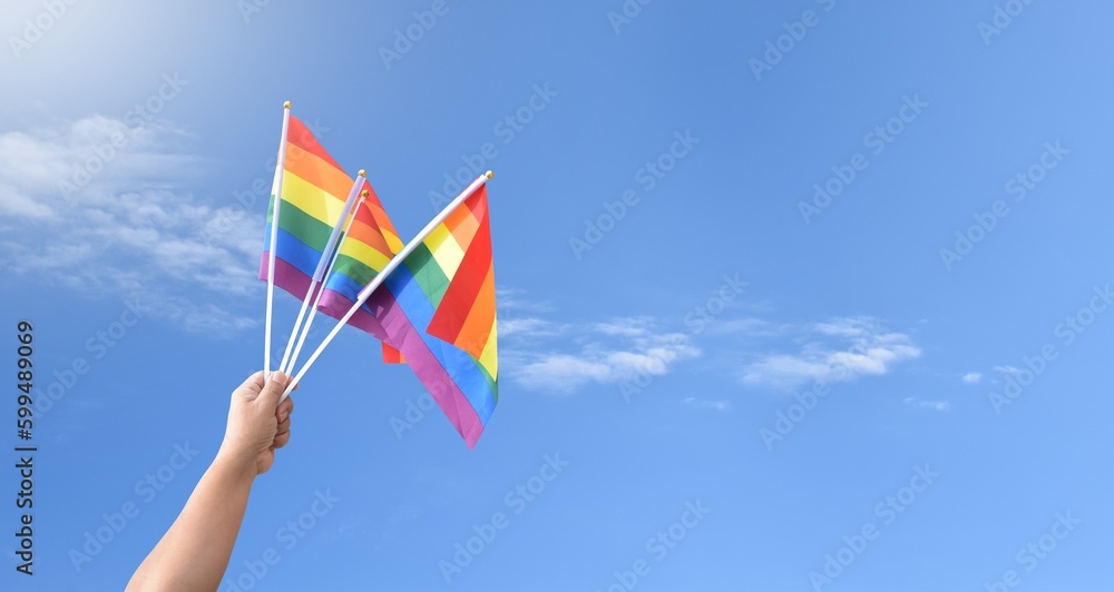 Rainbow flag raising against cloudy and bluesky background, copy space, concept for LGBT celebrations in pride month, June, around the world. Rainbow flag raising against cloudy and bluesky background, copy space, concept for LGBT celebrations in pride month, June, around the world.