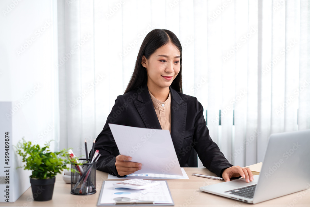 Smart business woman is sitting at workplace and planing about marketing investment from the graph. Smart business woman is sitting at workplace and planing about marketing investment from the graph.