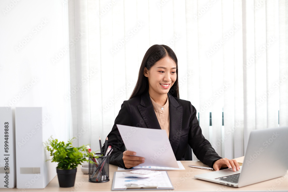 Smart business woman is sitting at workplace and planing about marketing investment from the graph. Smart business woman is sitting at workplace and planing about marketing investment from the graph.