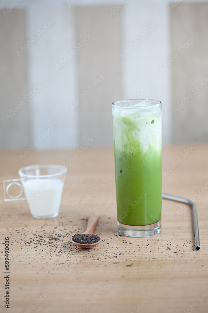 Iced Green matcha tea mixed with ice cube and milk in latte glass on white. Space for text. Close up. Iced Green matcha tea mixed with ice cube and milk in latte glass on white. Space for text. Close up.