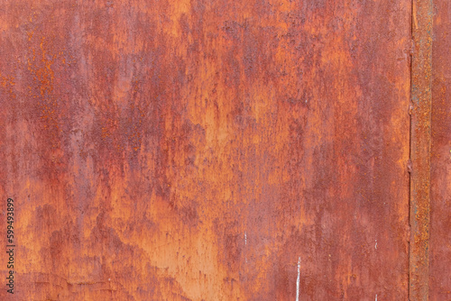 detail of the texture of an antique rusty metallic door painted red