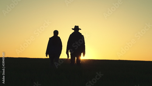 Farmer silhouette. two partners sunset shake hands with each other. business concept. tablet box. team farmers negotiate deal. group workers. Wheat field. smart farm tablet. Business deal farm.