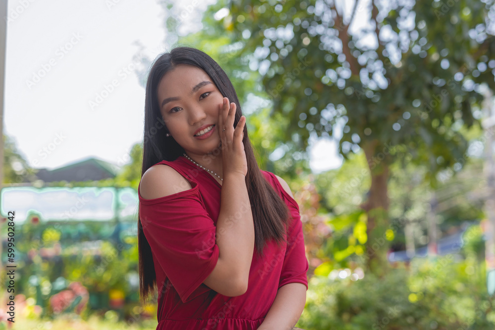 A close- up image of a lovely Asian woman tells a secret or whispers a gossip by hiding her mouth to the opposite side A close- up image of a lovely Asian woman tells a secret or whispers a gossip by hiding her mouth to the opposite side