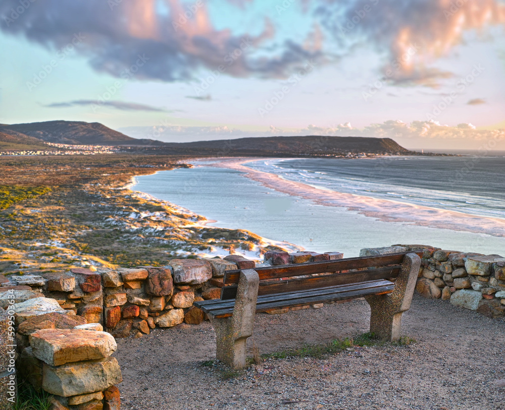 Perfect place to enjoy the view. A park bench overlooking a picturesque beach.