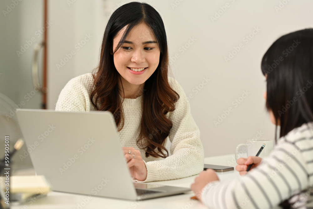 Loving young asian mom or tutor teacher helping little daughter with distance learning online virtual class on laptop Loving young asian mom or tutor teacher helping little daughter with distance learning online virtual class on laptop