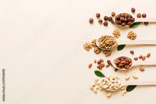 mixed nuts in white wooden spoon. Mix of various nuts on colored background. pistachios, cashews, walnuts, hazelnuts, peanuts and brazil nuts