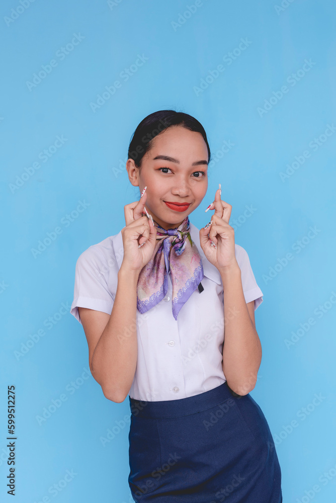 A flight attendant doing the fingers crossed sign. A stewardess wishing for good luck. Two hands. A flight attendant doing the fingers crossed sign. A stewardess wishing for good luck. Two hands.