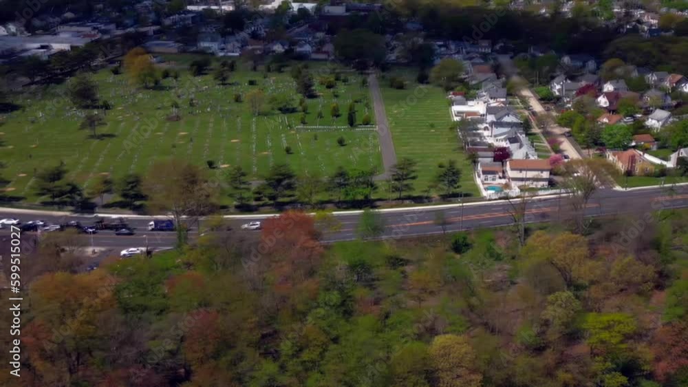 An aerial time lapse of white clouds over a suburban neighborhood on Long Island, New York on a sunny day. The drone camera dolly out, pan left and boom down over a pond with green trees. An aerial time lapse of white clouds over a suburban neighborhood on Long Island, New York on a sunny day. The drone camera dolly out, pan left and boom down over a pond with green trees.