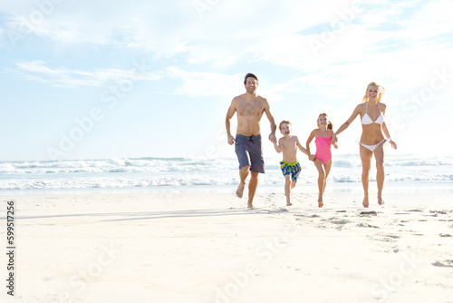 Family makes the fun. a happy young family running on the beach together.