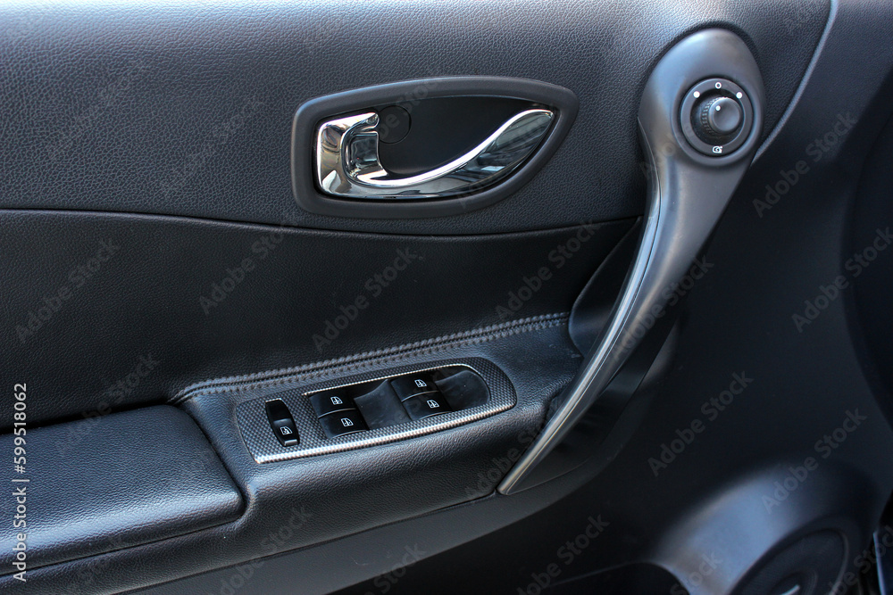Window control buttons in modern car. Car window control panel. Door handle with power window control. Close up old car interior. 