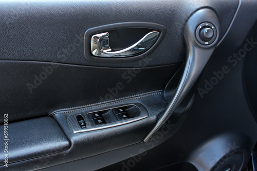 Window control buttons in modern car. Car window control panel. Door handle with power window control. Close up old car interior. 