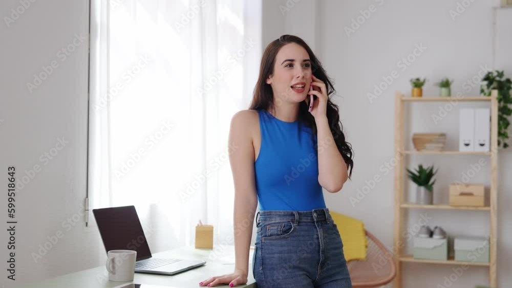 Young woman talking on the phone in home office. Young woman talking on the phone in home office.