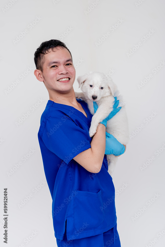 A joyful and delighted nursing aide or nurse posing while holding a puppy. Isolated on a white background. A joyful and delighted nursing aide or nurse posing while holding a puppy. Isolated on a white background.