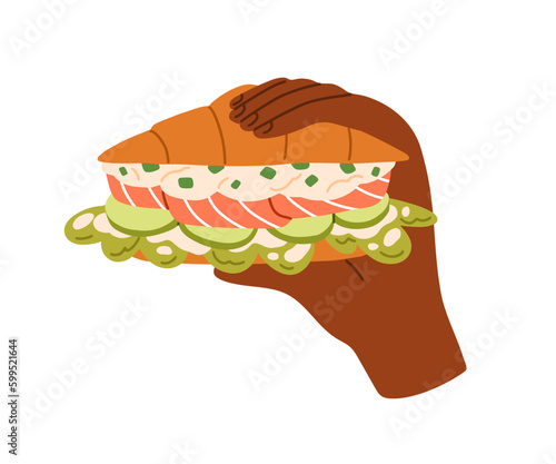 Hand holding croissant, French sandwich with salmon, lettuce. Tasty takeaway ...