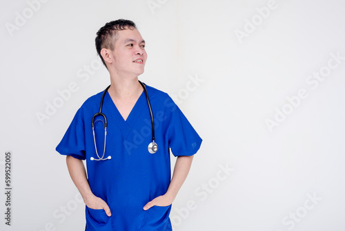 Portrait of a young and skilled medical student, nurse, intern posing with both hands inside pockets. Isolated on a white background.