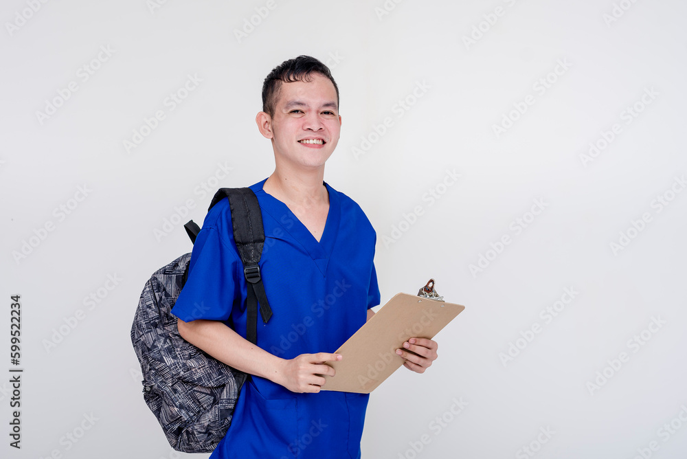 Portrait of a young and bubbly caregiver, nurse, nursing aide on the way to work wearing a backpack and holding a checklist board and pen. Isolated on a white background. Portrait of a young and bubbly caregiver, nurse, nursing aide on the way to work wearing a backpack and holding a checklist board and pen. Isolated on a white background.