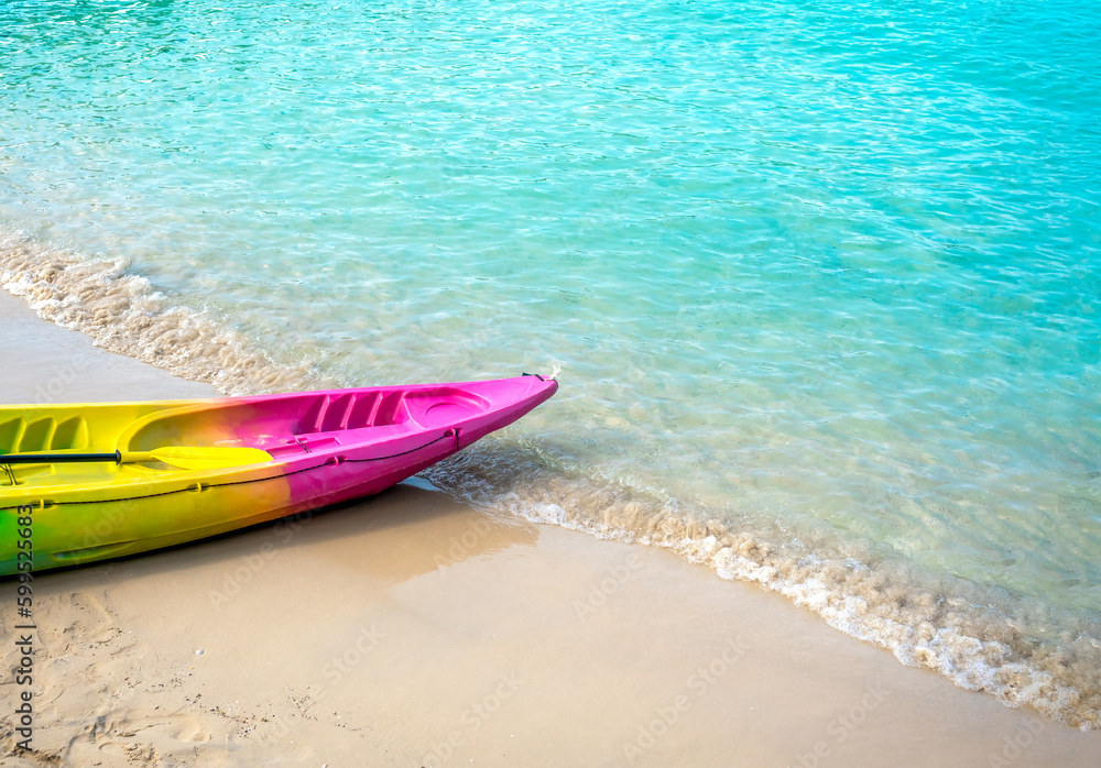 Colorful kayak with nobody on clean sandy beach and blue sea background with copy space, activity equipment prepare for hotel or resort guests on holiday summer vacation travel. Colorful kayak with nobody on clean sandy beach and blue sea background with copy space, activity equipment prepare for hotel or resort guests on holiday summer vacation travel.