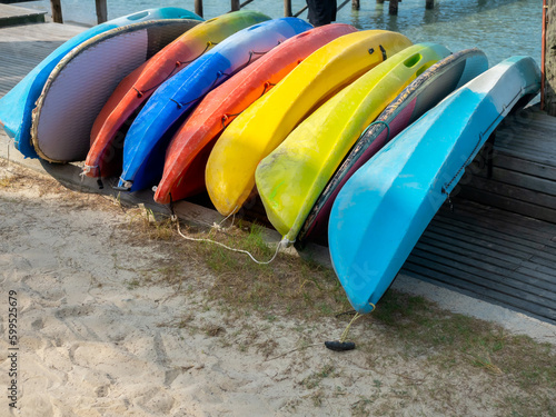 Multi colored kayak on sandy beach prepare for hotel or resort guests on holiday summer vacation travel.